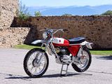 a red and white motorcycle parked in front of a stone wall