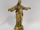 statue en laiton représentant Jésus tenant la croix, sur fond blanc