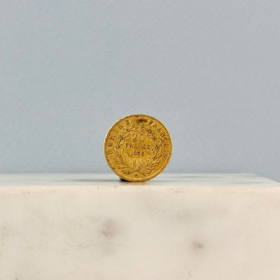 une pièce d'or posée sur un bloc de marbre