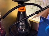 a black hook on a counter with a box of coffee beans and a box of coffee beans
