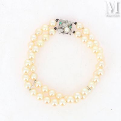 a close up of a pearl bracelet with a diamond clasp