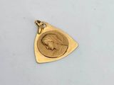 a close up of a gold pendant with a bird on it