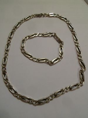 collier et bracelet en métal argenté sur fond blanc