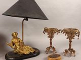 a lamp and a statue on a table next to a clock