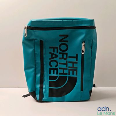 le sac à dos bleu et noir de la marque The North Face posé sur une surface blanche