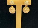 a close up of a pair of earrings on a stand