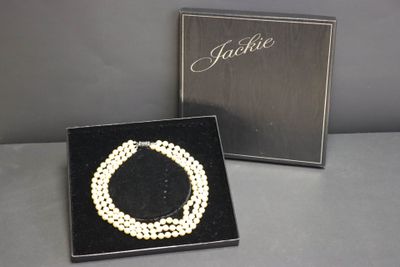 un gros plan sur un collier et un coffret posés sur une table