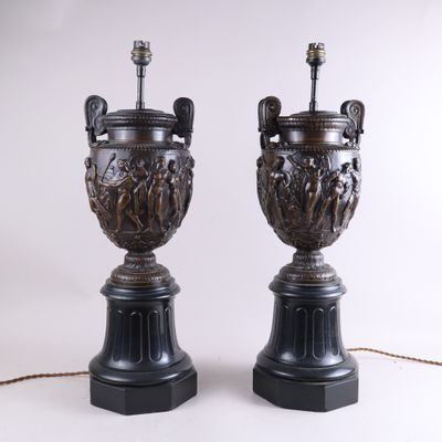 paire d'urnes antiques en bronze posées sur des socles en marbre noir