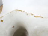 a white porcelain vase with a gold decoration on it