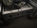 une cuisinière sur laquelle sont posées une casserole et une poêle, dans une cuisine