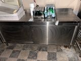 a stainless steel counter with several bottles of water on it