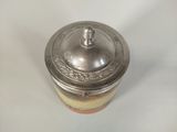 an antique silver lidded jar with a lid on a white surface