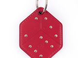 un porte-clés en cuir rouge avec des rivets sur fond blanc