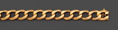 gros plan d'un bracelet en or sur une surface grise