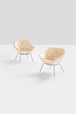pair of lounge chairs in the shape of a shell
