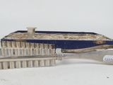 silverware in a blue box with a spoon and spoon rest in it