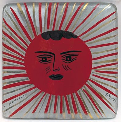 a picture of a red and gold plate with a face