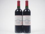 deux bouteilles de vin rouge posées l'une à côté de l'autre sur une surface blanche