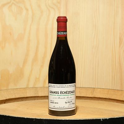 a bottle of wine sitting on top of a barrel