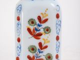 a small glass bottle with a floral design on it
