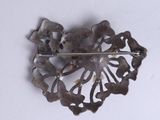 a metal brooch that has a flower design on it