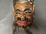a wooden mask that is on display on a table