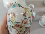 a person holding a white vase with a picture of people on it