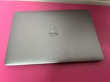 an apple laptop computer sitting on top of a pink table