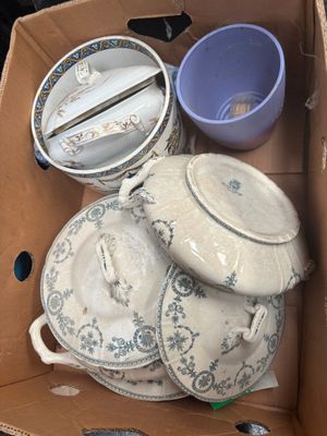 a cardboard box filled with plates and bowls