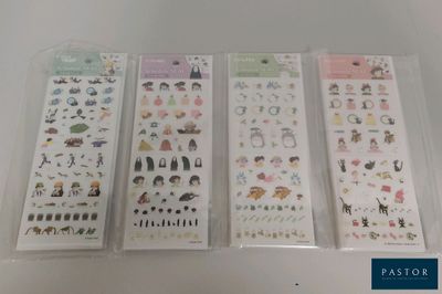 quatre types différents d'autocollants dans des sachets en plastique posés sur une table