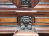 a wooden shelf with a lion head on it
