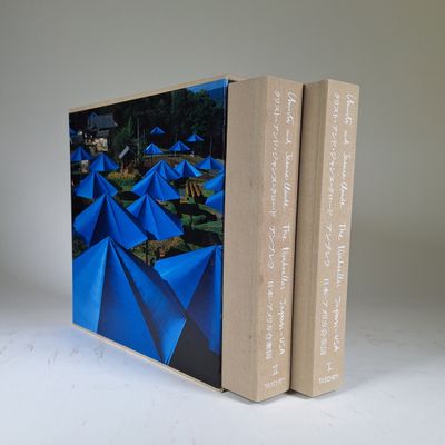 two books sitting on top of each other on a white surface
