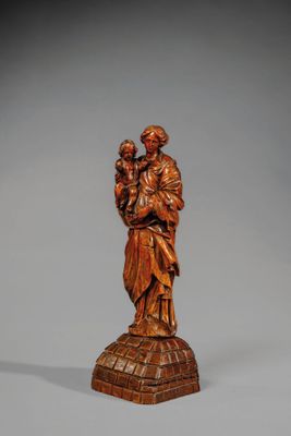 une statue en bois sculpté représentant un homme tenant un enfant dans ses bras