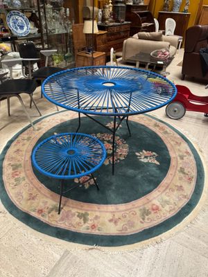 a blue table with two umbrellas on it in the middle of a room