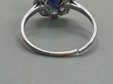 an image of a ring with a blue stone in the center