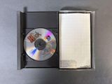 a cd in a box with a notepad on it