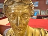a gold statue of a man with a crown on his head