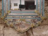 a mirror hanging on a stone wall with a blue frame