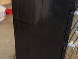a black stove sitting on a cart in the middle of a room