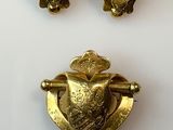 three pieces of gold colored metal with a bird on it