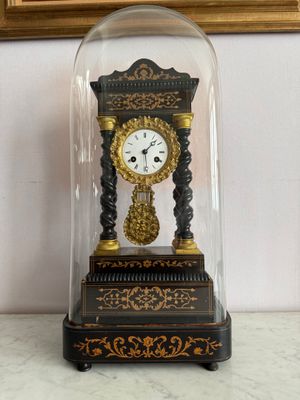 a small clock under a glass dome on a table