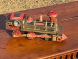 un petit train miniature posé sur une table en bois posée à même le sol