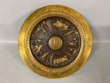une assiette en or ornée d'un motif sur fond blanc