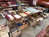 de nombreuses caisses de livres posées sur une table dans une pièce