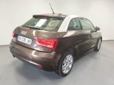 the back of a brown and white car parked in a garage