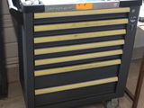 un chariot à outils noir et jaune sur lequel se trouve un ordinateur