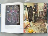 an open book with a picture of a woman working on a piece of art