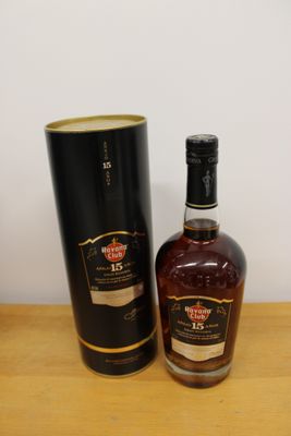 une bouteille de whisky posée à côté d'une boîte noire sur une table en bois