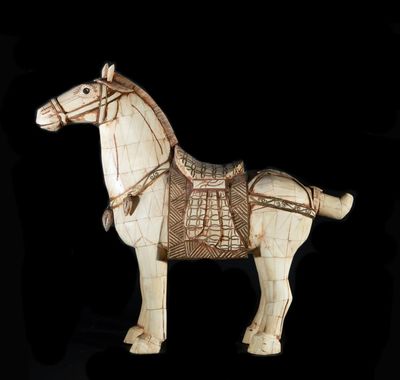 a wooden horse with a harness on it ' s back