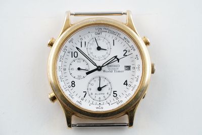 montre en or jaune avec cadran blanc et aiguilles noires sur fond blanc